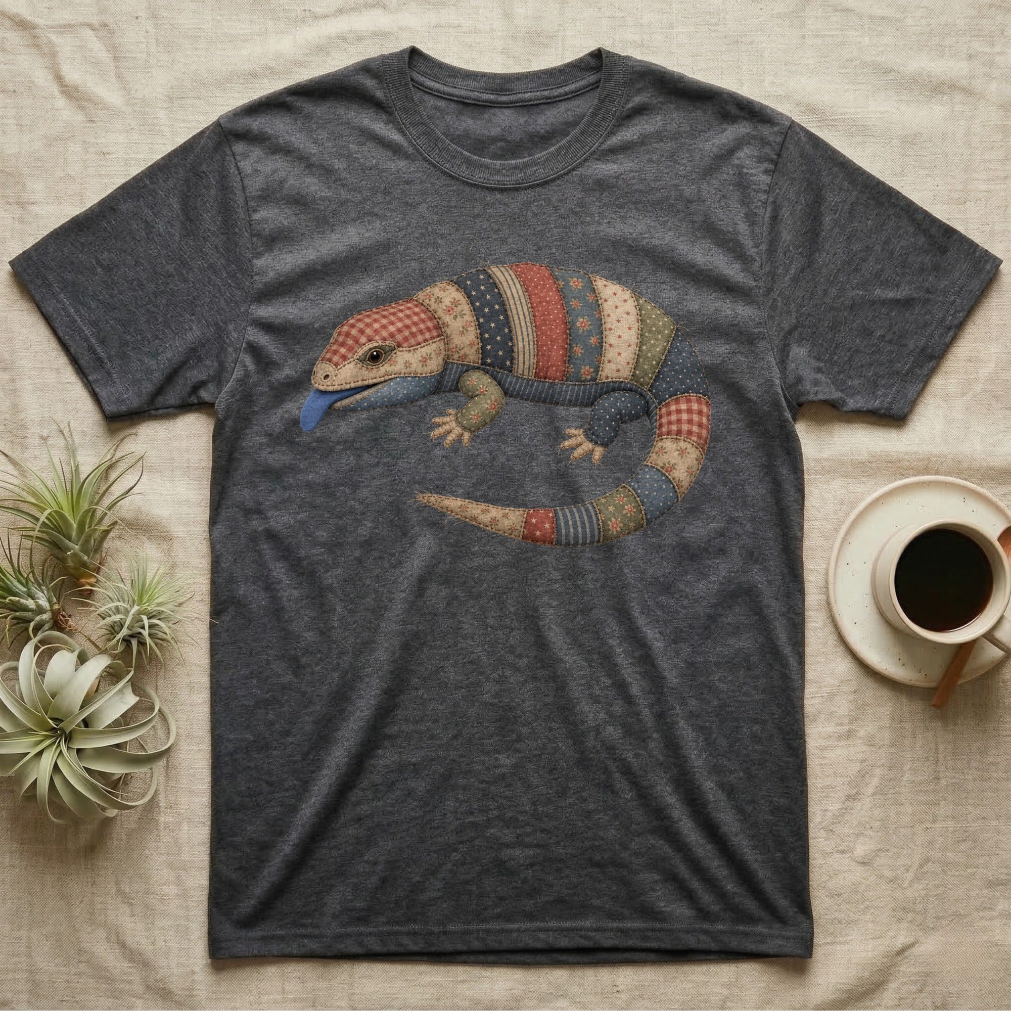 Dark grey t-shirt with a colorful patchwork lizard design and blue tongue.