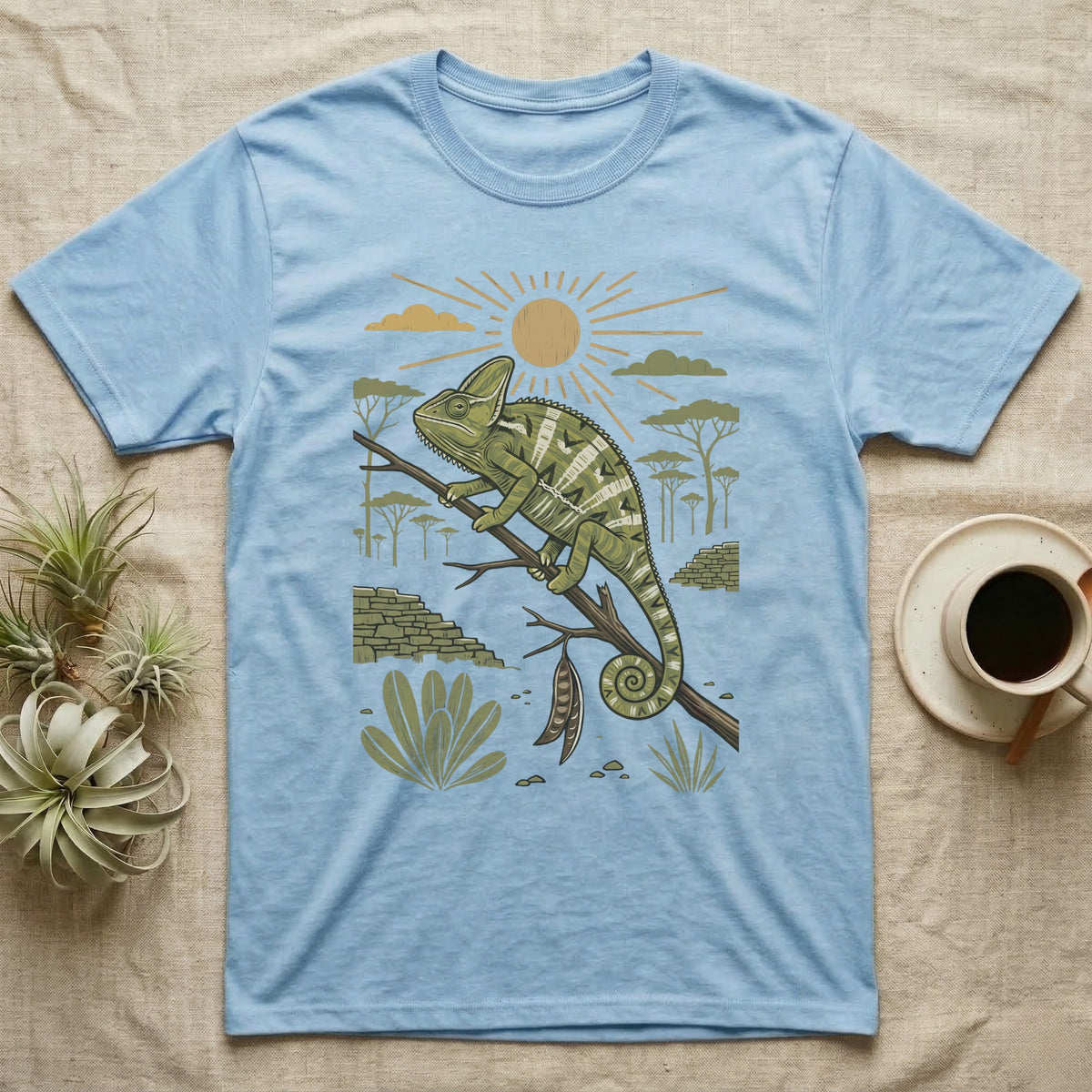 Veiled Chameleon Home Range T-Shirt in Light Blue — Woodcut-style illustration of a veiled chameleon gripping an acacia branch with terraced walls and umbrella trees behind, no on-shirt text.