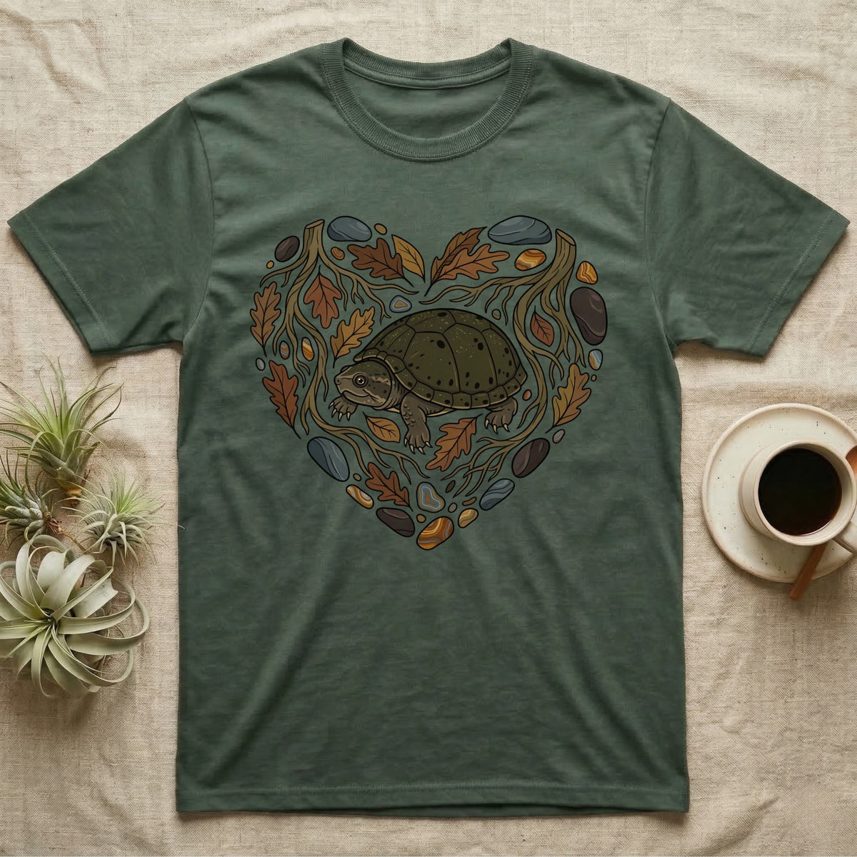 Green t-shirt with a heart design featuring a turtle, leaves, and rocks.