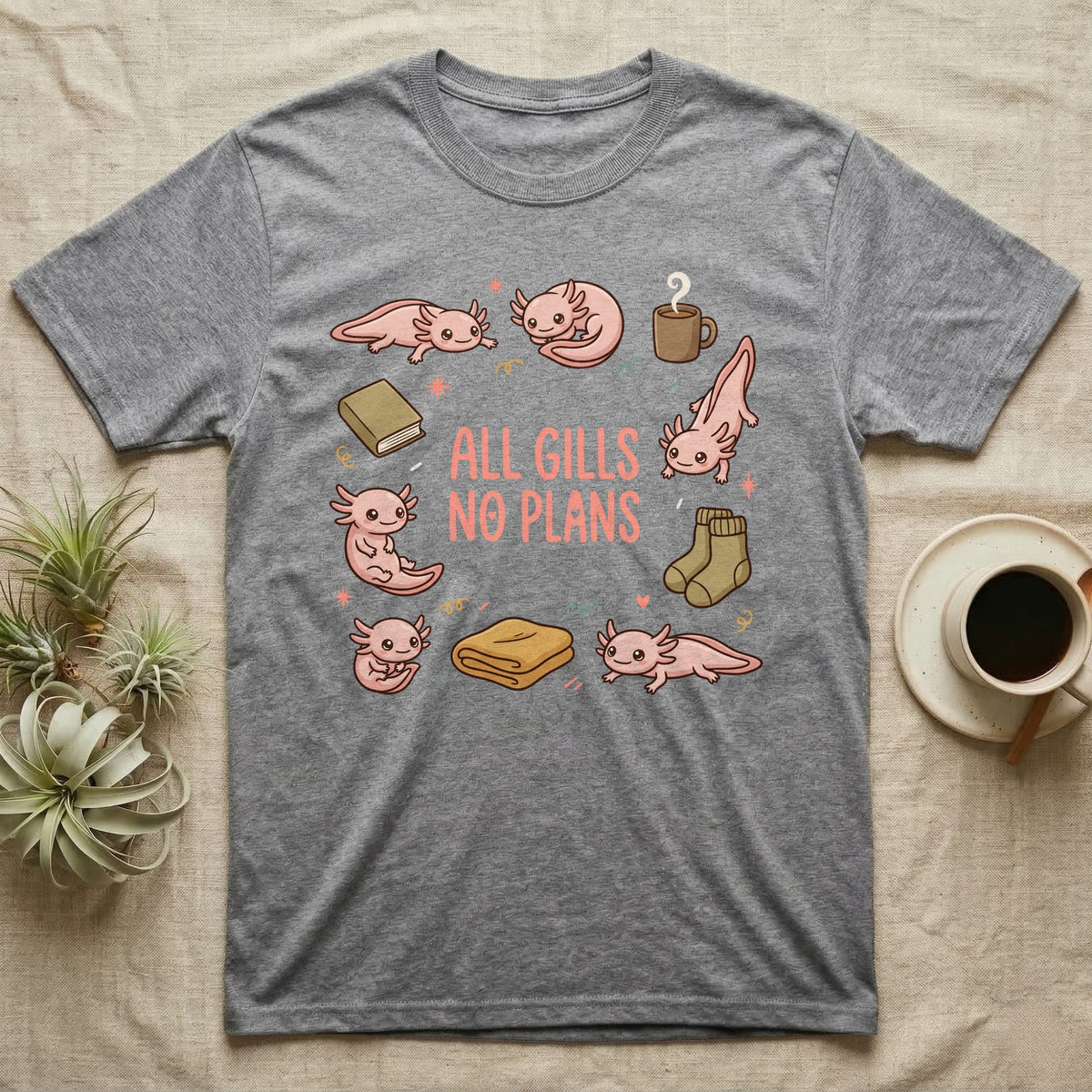 Axolotl All Gills No Plans T-Shirt in Sport Grey — Cartoon sticker collection of six leucistic axolotls resting among a mug, socks, a blanket and a book, under the words ALL GILLS NO PLANS.