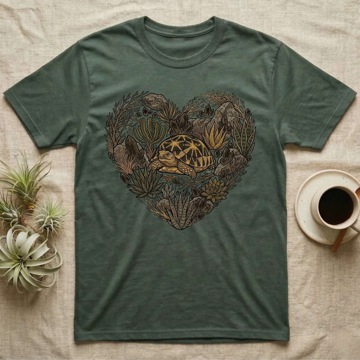 Green t-shirt with a heart-shaped design of a turtle and foliage.