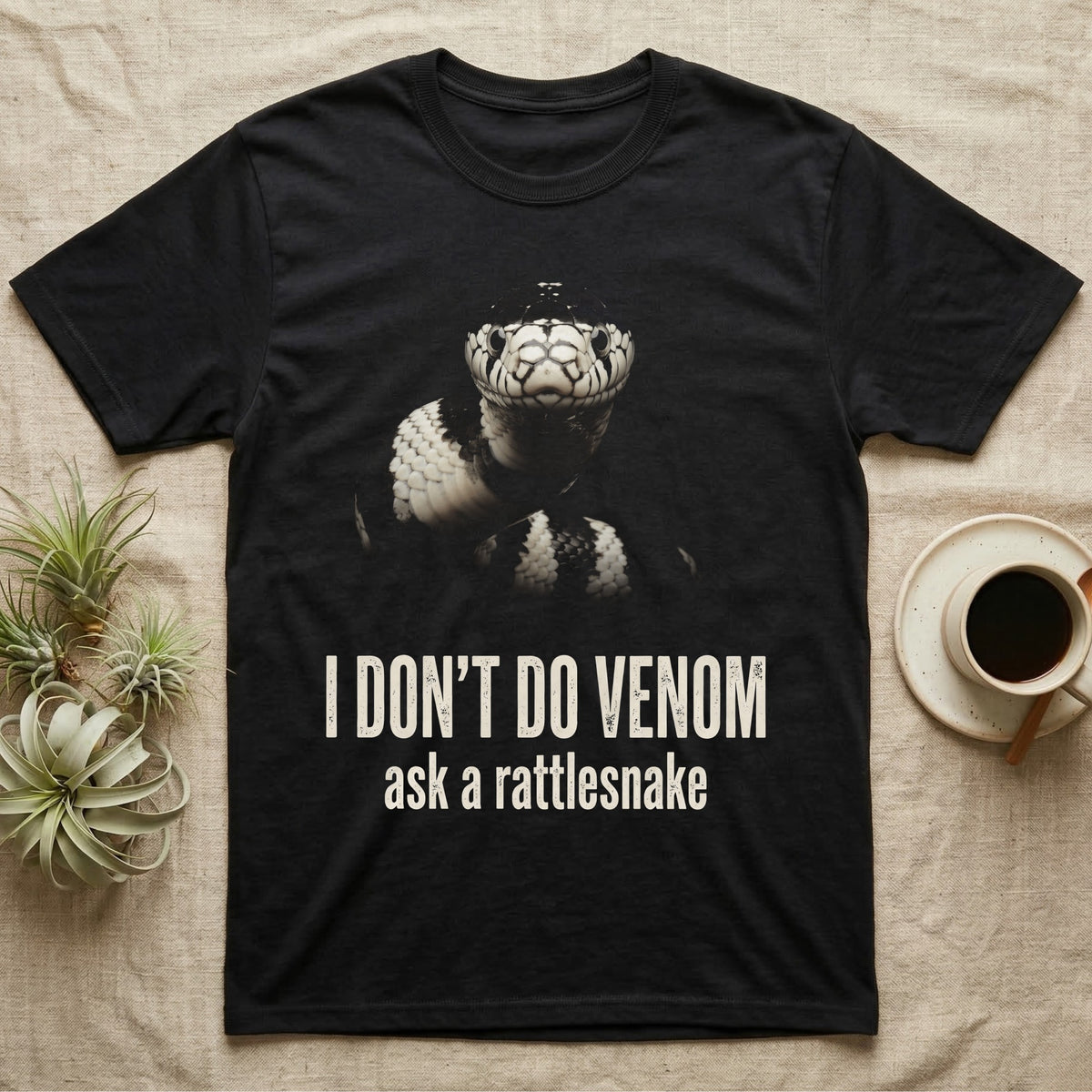 Deadpan photographic mugshot of a California kingsnake raised head-level to the camera above the distressed text I Don't Do Venom, ask a rattlesnake. — shown on a Black tee.