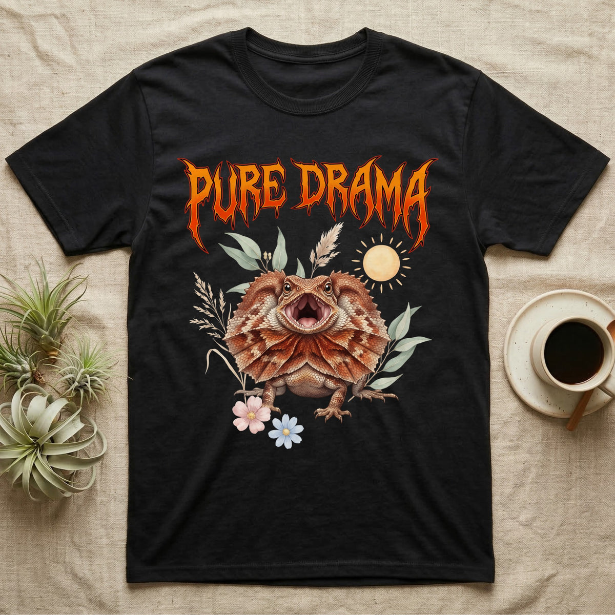 Frilled Dragon Feral T-Shirt in Black — Frilled dragon with its neck frill flared and mouth gaping under a jagged fiery-orange metal "PURE DRAMA" wordmark.
