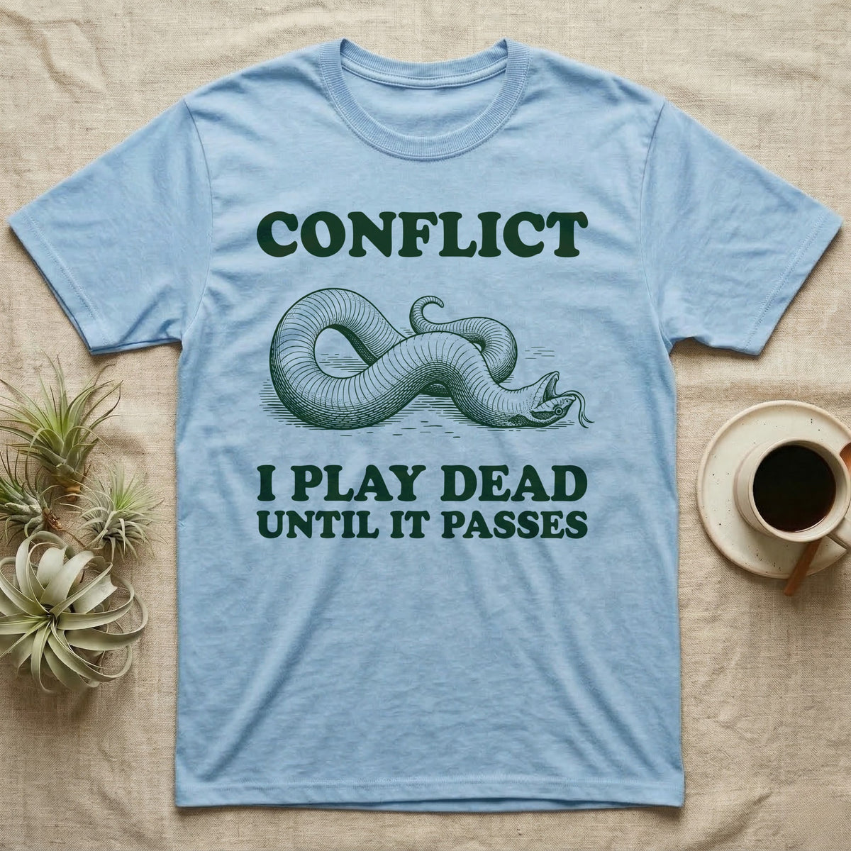 Hognose Conflict T-Shirt in Light Blue — Engraved western hognose snake twisted over and playing dead with its tongue out, between the words CONFLICT and I PLAY DEAD UNTIL IT PASSES.