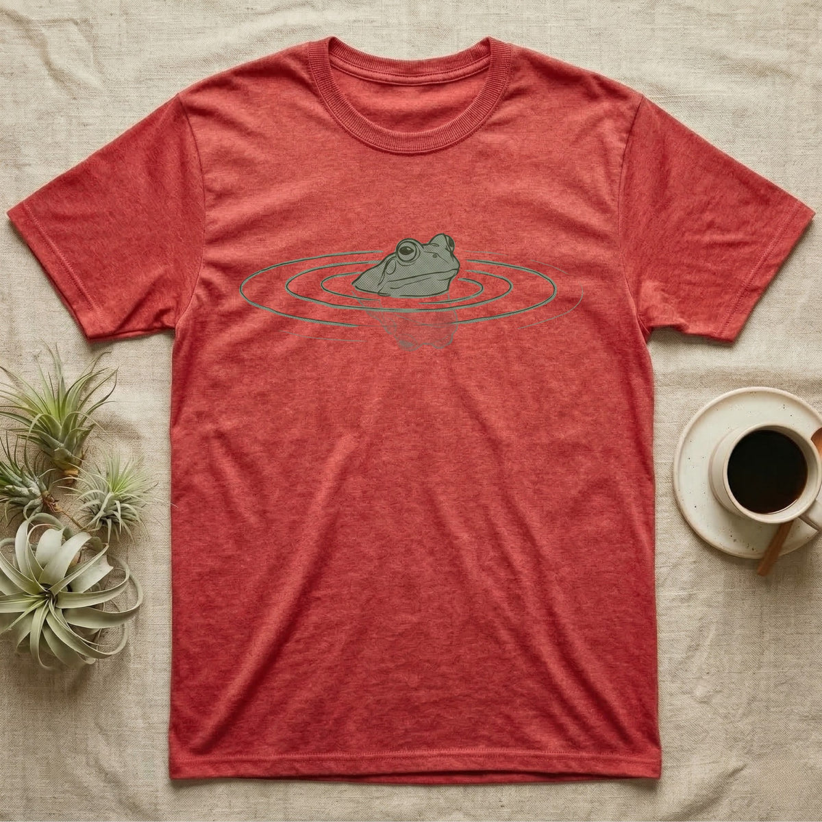 Minimal Swimming Frog T-Shirt in Heather Red — Minimal single-line illustration of a frog at the waterline with concentric ripple rings and vast negative space.