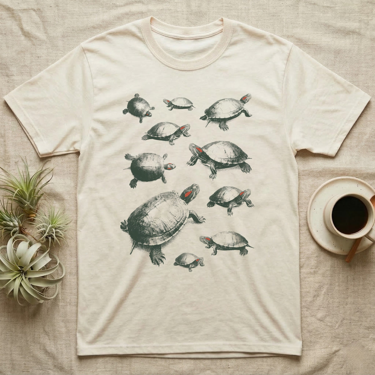 Red-Eared Slider Specimen T-Shirt in Natural — One red-eared slider repeated ten times in olive-green screen-print specks, each at a different size and angle, with a small red stripe behind every eye.