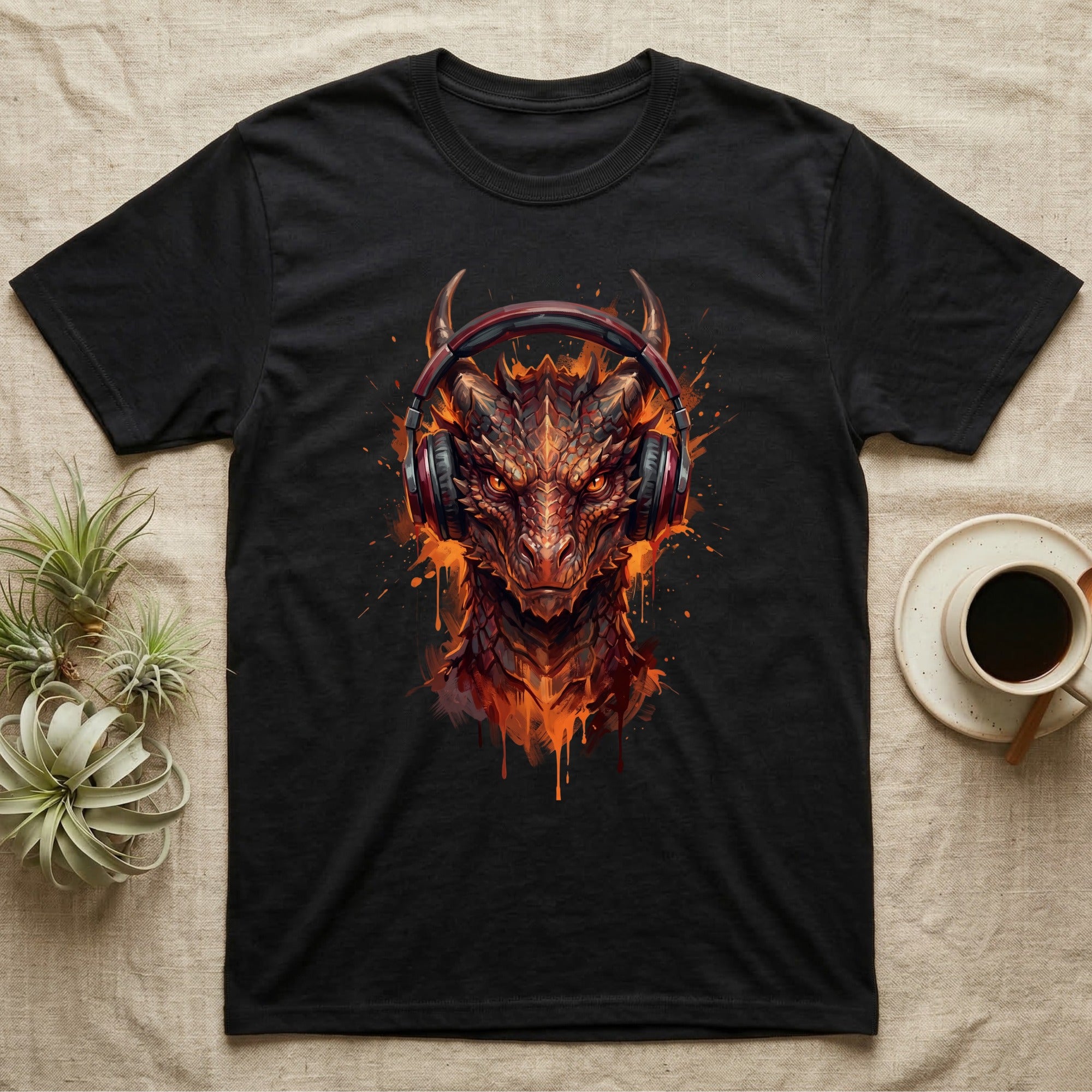 Black t-shirt with a fiery dragon wearing headphones, with coffee and plants.