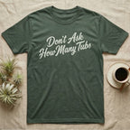 Snake Tubs T-Shirt in Military Green — Worn off-white 1970s retro brush script climbing a diagonal on charcoal, reading Don't Ask How Many Tubs