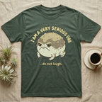 Dark green t-shirt with a grumpy toad and text "I AM A VERY SERIOUS ORB ...do not laugh."