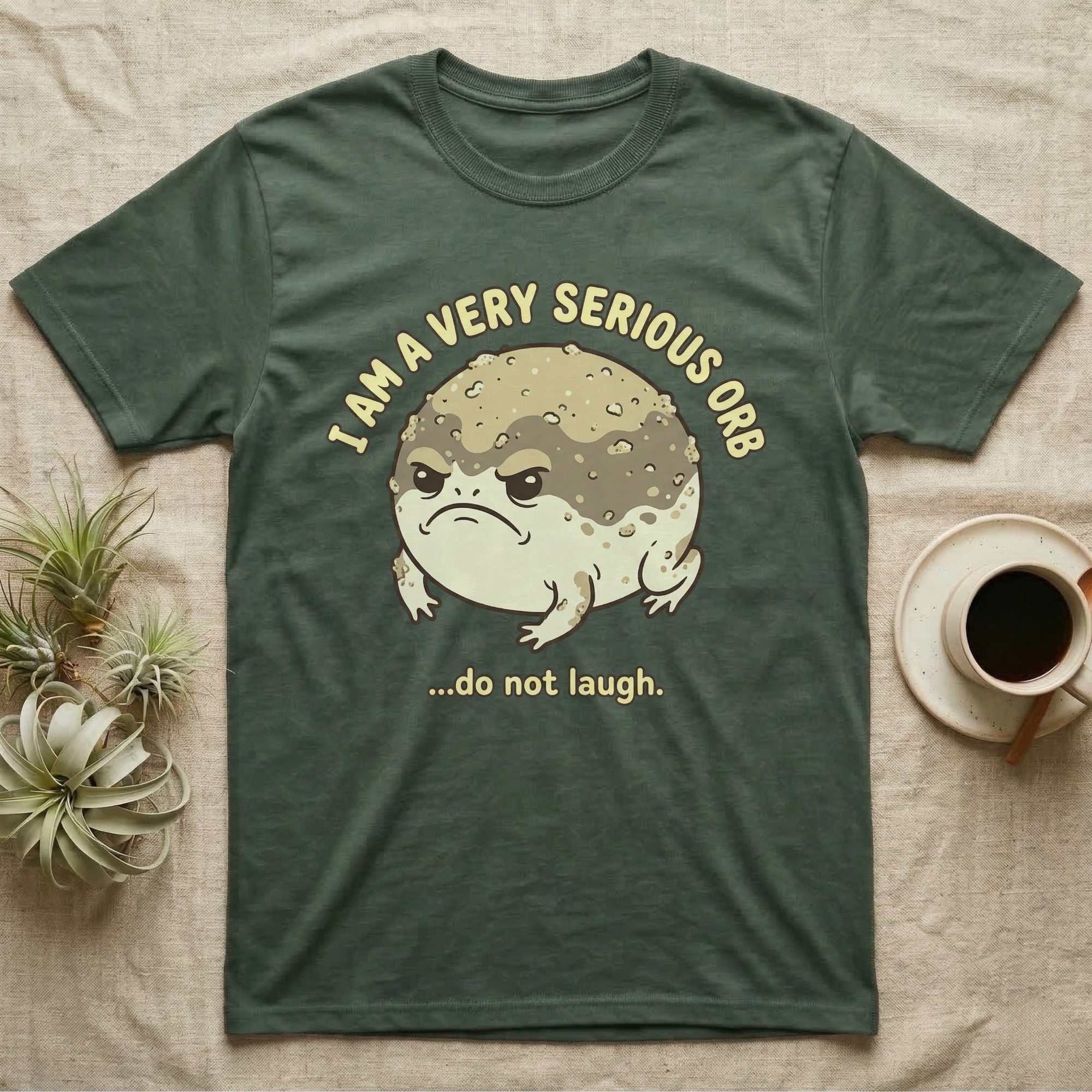 Dark green t-shirt with a grumpy toad and text "I AM A VERY SERIOUS ORB ...do not laugh."