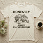 Snapping Turtle Judgements T-Shirt in Natural — Engraved snapping turtle standing, head forward, with the words Honestly, I Make Snap Judgements