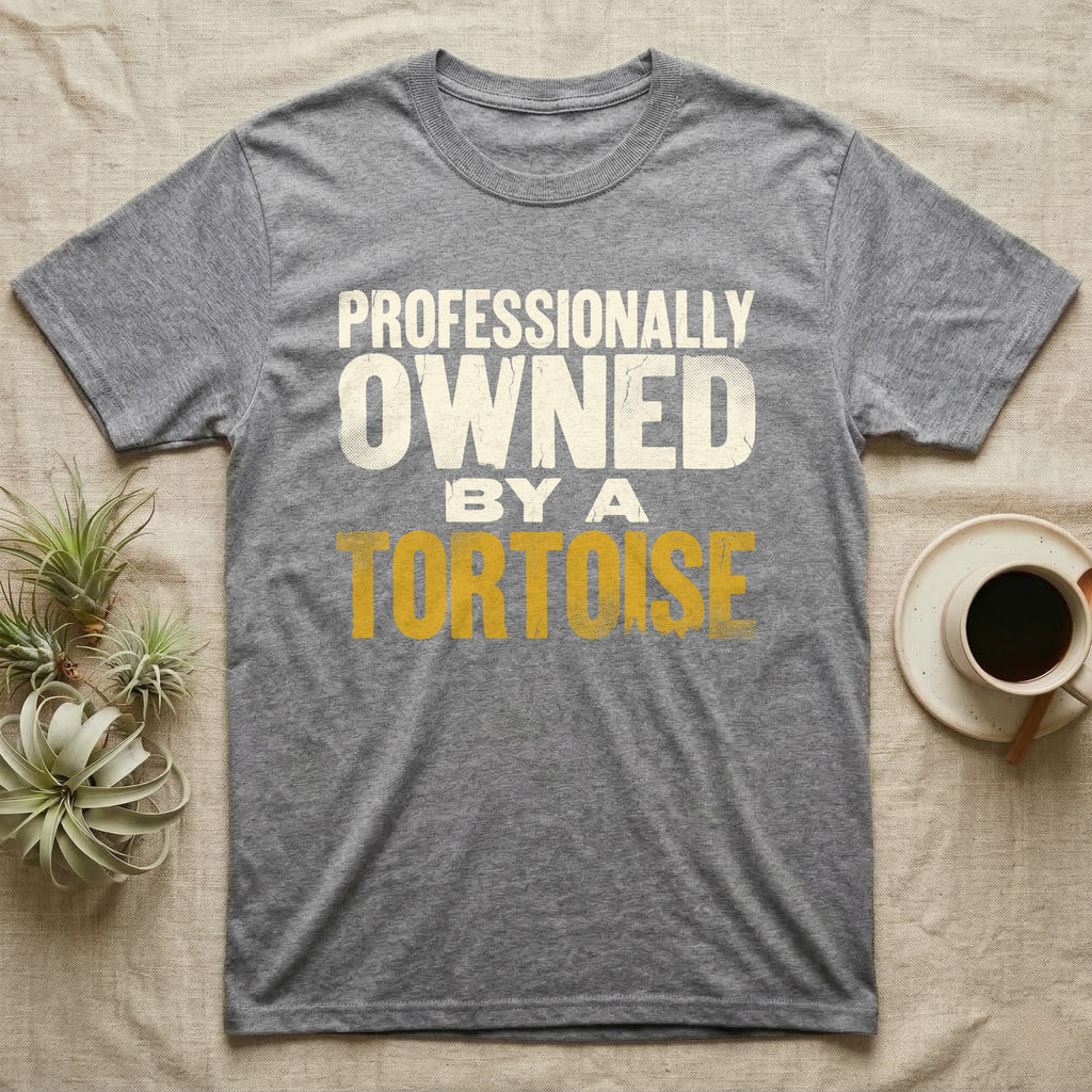 Owned By A Tortoise T-Shirt in Sport Grey — Distressed woodtype wordmark reading professionally owned by a tortoise in a bold two-tier lockup, text only.