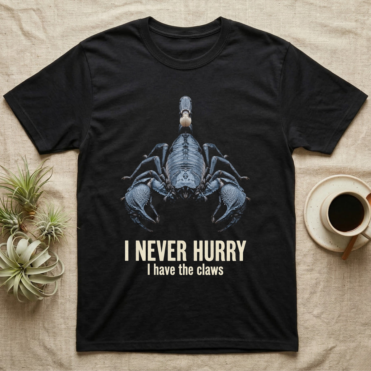 Flat-black mug-shot portrait of an emperor scorpion with claws spread toward the camera, with the printed words I Never Hurry, I have the claws. — shown on a Black tee.