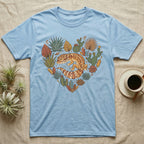 Light blue t-shirt with a heart-shaped design of a gecko and succulents.