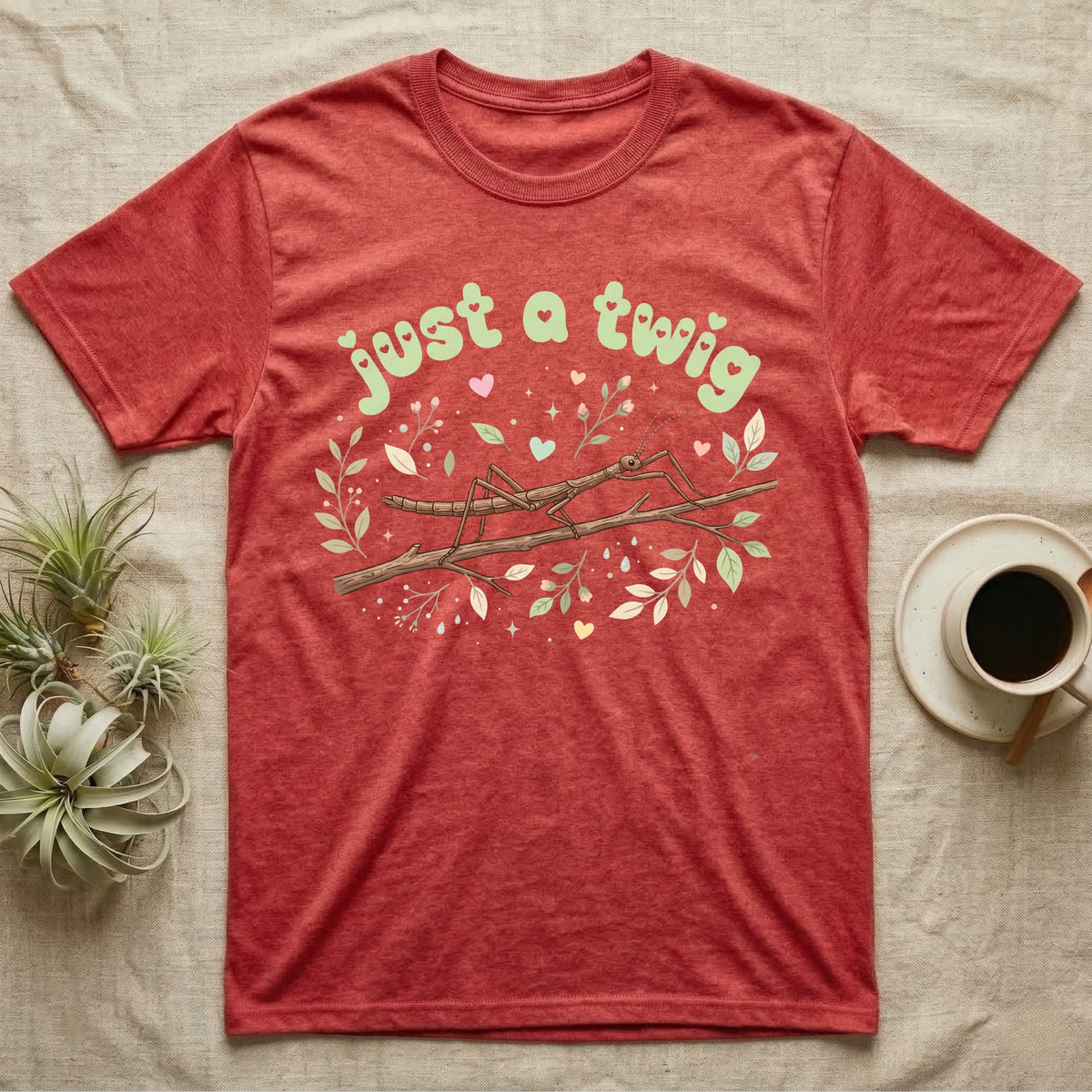 Stick Insect Softie T-Shirt in Heather Red — Camouflaged stick insect on a branch under pastel bubble text "just a twig" with tiny hearts.