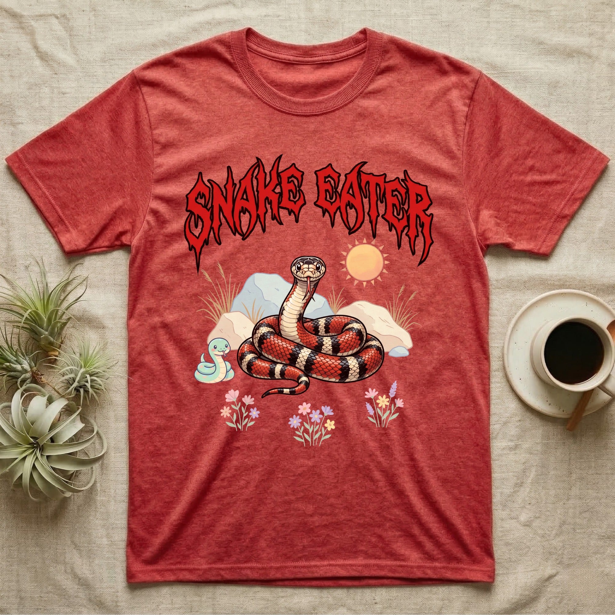 California Kingsnake Feral T-Shirt in Heather Red — Banded California kingsnake coiled with a tiny companion snake under a jagged blood-red metal wordmark and pastel scene.