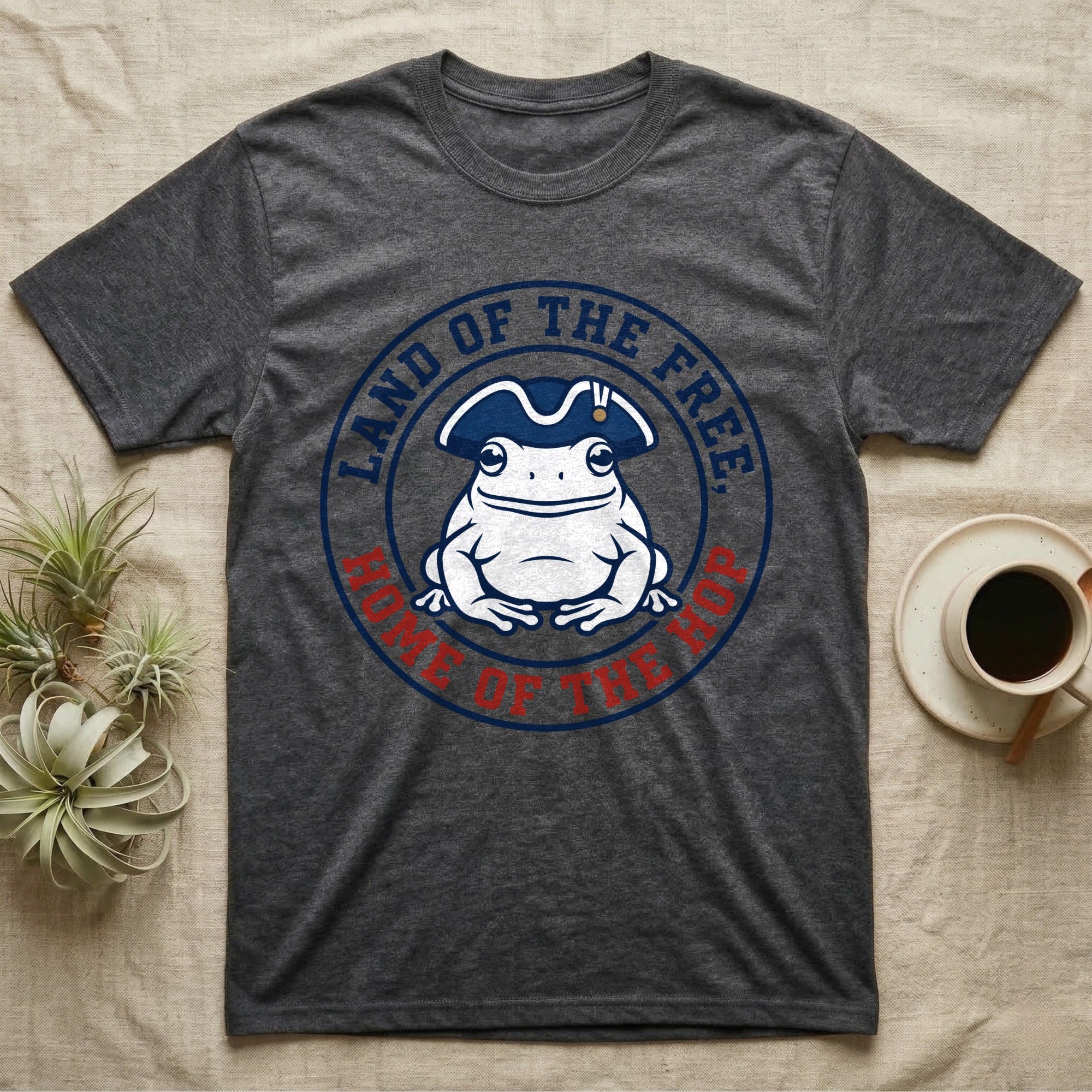 American Toad Emblem T-Shirt in Dark Heather — Round emblem of a white American toad silhouette in a tricorn hat with text Land of the Free, Home of the Hop.