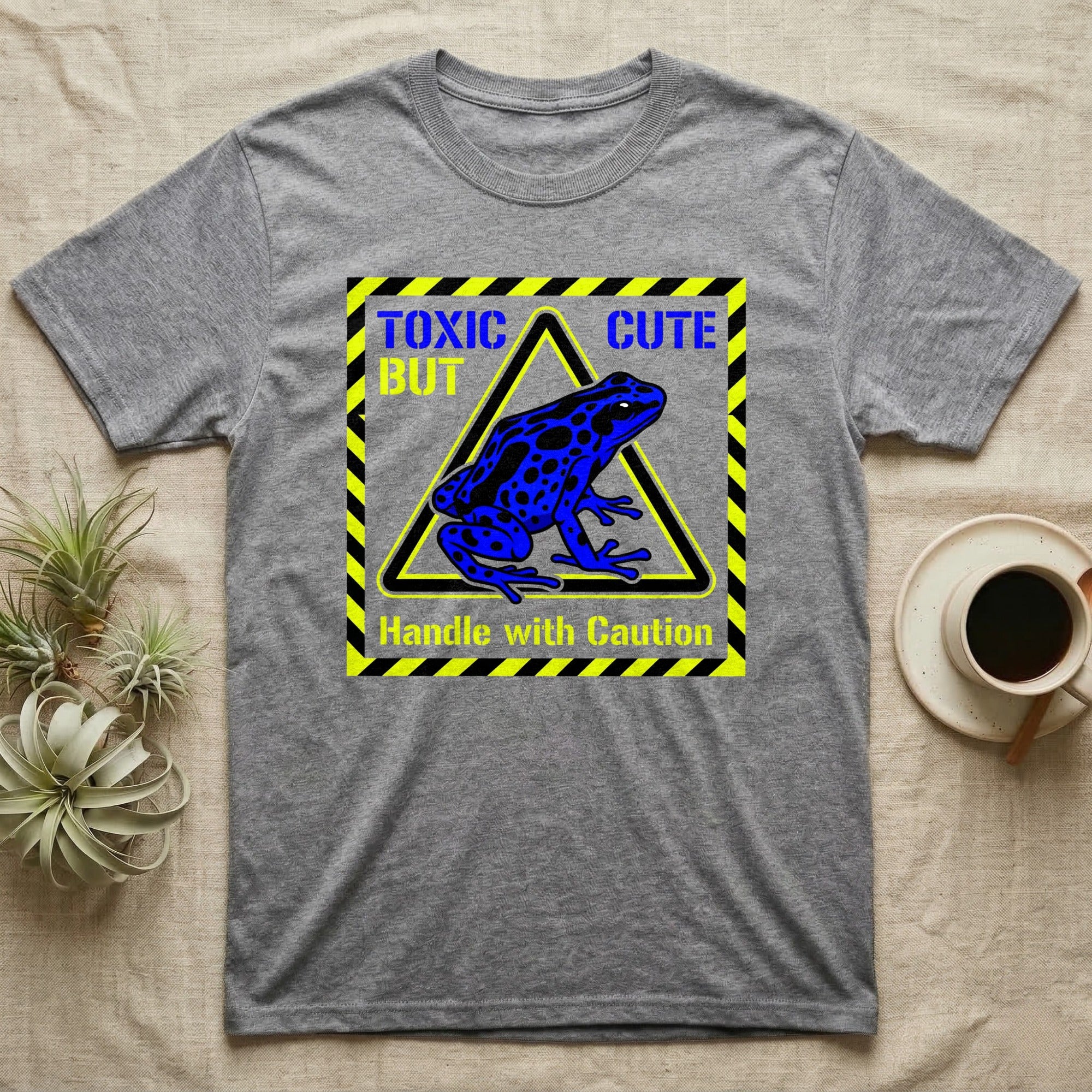 Gray t-shirt with "Toxic But Cute" and blue frog on warning sign.