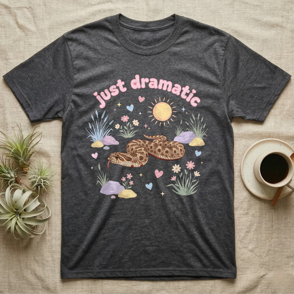 Western Hognose Snake Baby T-Shirt in Dark Heather — Pastel western hognose snake in a low coil with tongue out among grasses, puffy pink bubble wordmark "just dramatic" above.