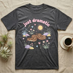 Western Hognose Snake Baby T-Shirt in Dark Heather — Pastel western hognose snake in a low coil with tongue out among grasses, puffy pink bubble wordmark "just dramatic" above.