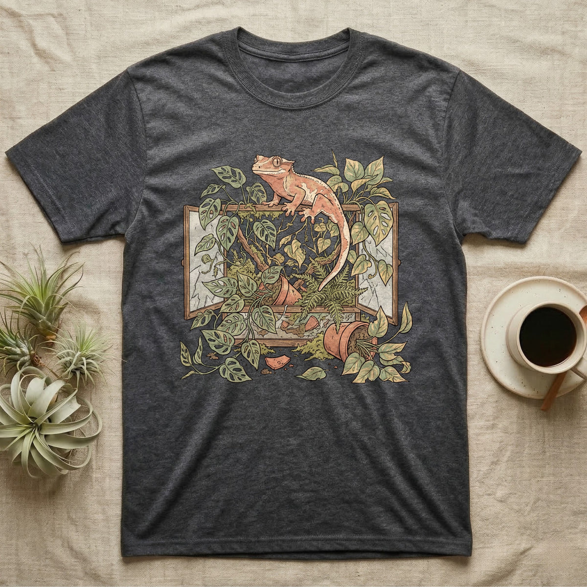 Bioactive Crested Gecko T-Shirt in Dark Heather — Botanical illustration of a smug crested gecko perched atop a lush overgrown planted vivarium spilling vines.