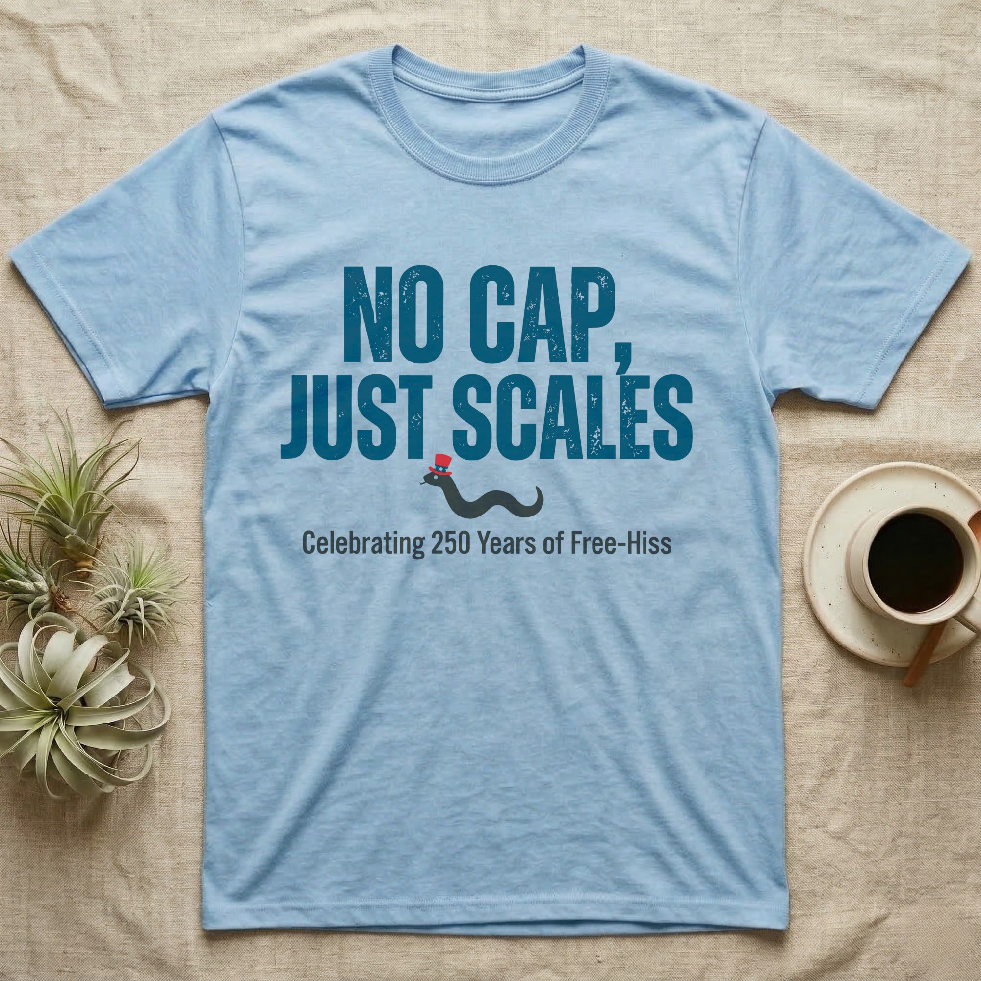 Rattlesnake No Cap T-Shirt in Light Blue — Big distressed text No Cap Just Scales over a tiny snake in a red top hat with 250 Years of Free-Hiss below.