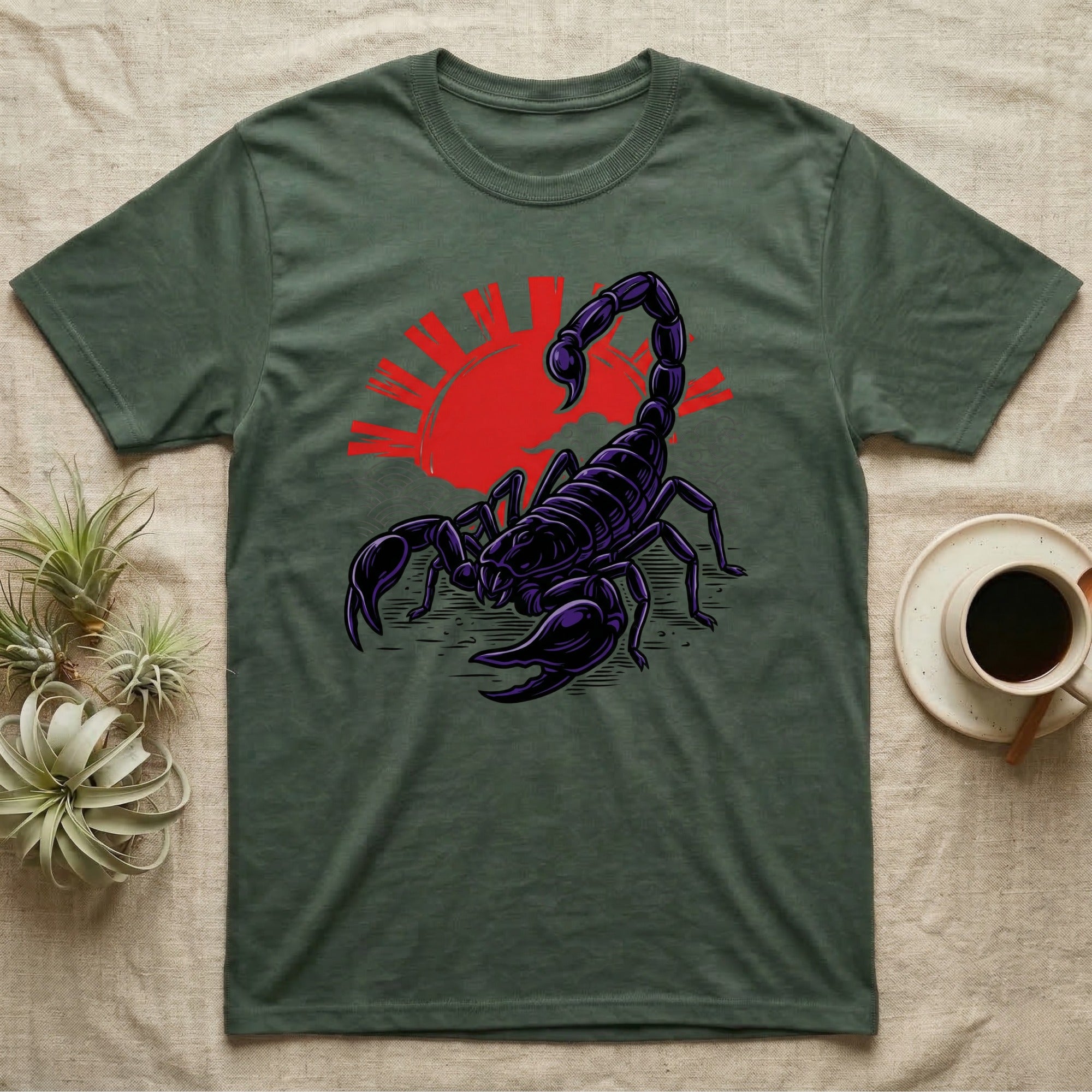 Dark scorpion illustration with red sunburst on a green t-shirt.
