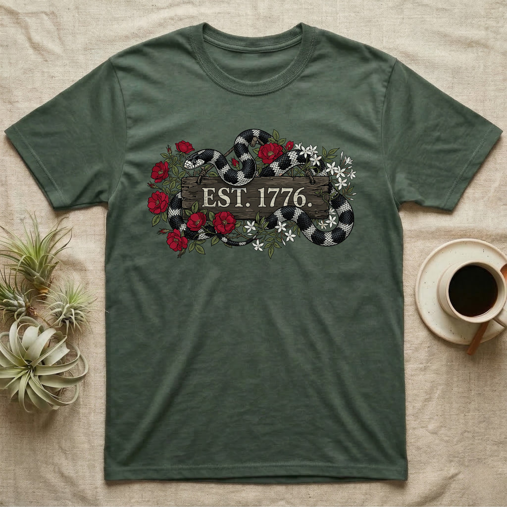 Kingsnake Floral 1776 T-Shirt in Military Green — Black-and-white California kingsnake woven through roses and jasmine around a wooden sign reading Est. 1776.