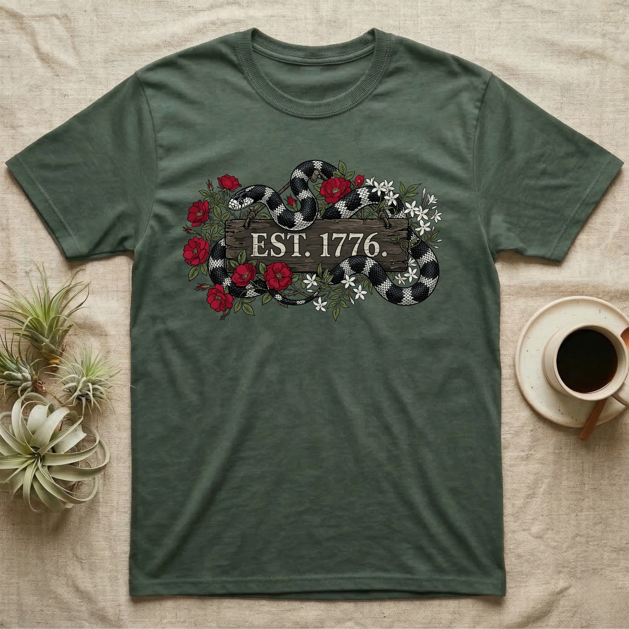 Kingsnake Floral 1776 T-Shirt in Military Green — Black-and-white California kingsnake woven through roses and jasmine around a wooden sign reading Est. 1776.