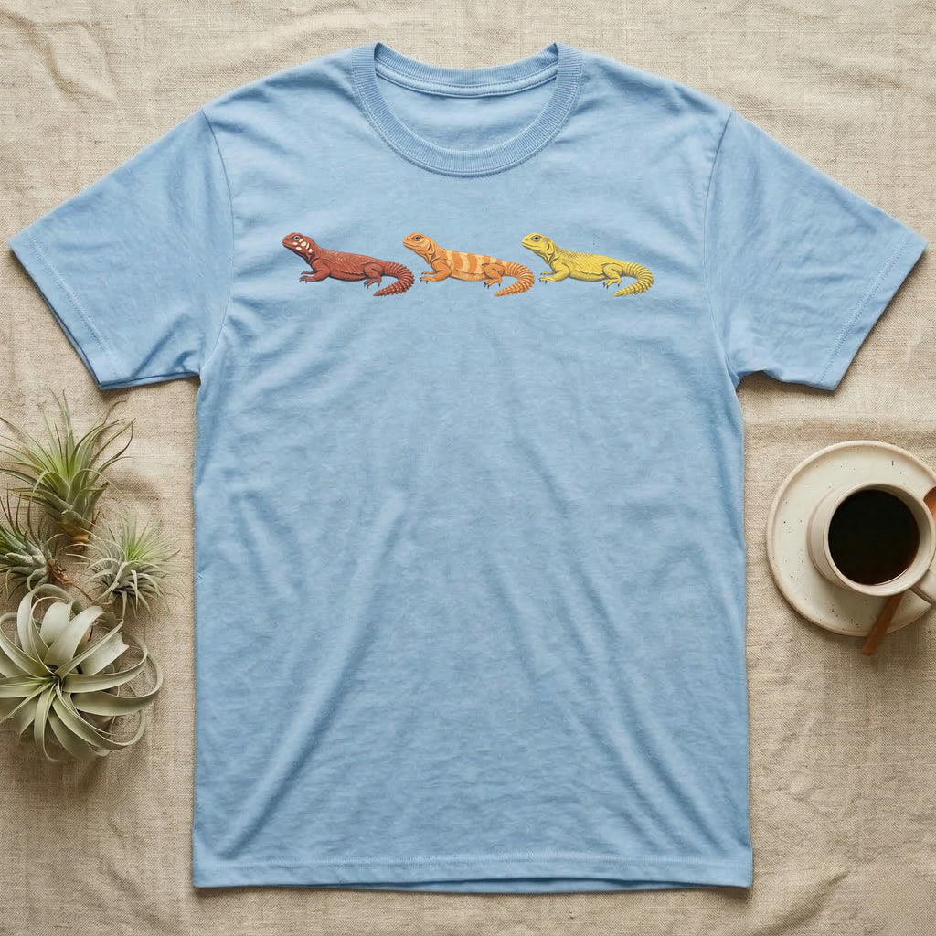 Uromastyx Colour Morph Trio T-Shirt in Light Blue — Three uromastyx lizards in a row, painted in thick raised relief — brick red, tangerine orange and lemon yellow morphs.