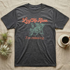 Solomon Islands Leaf Frog Chillin T-Shirt in Dark Heather — Illustrated Solomon Islands leaf frog reclining in a beach chair with sunglasses and a cocktail, coral script reading Leaf Me Alone I'm Relaxing.