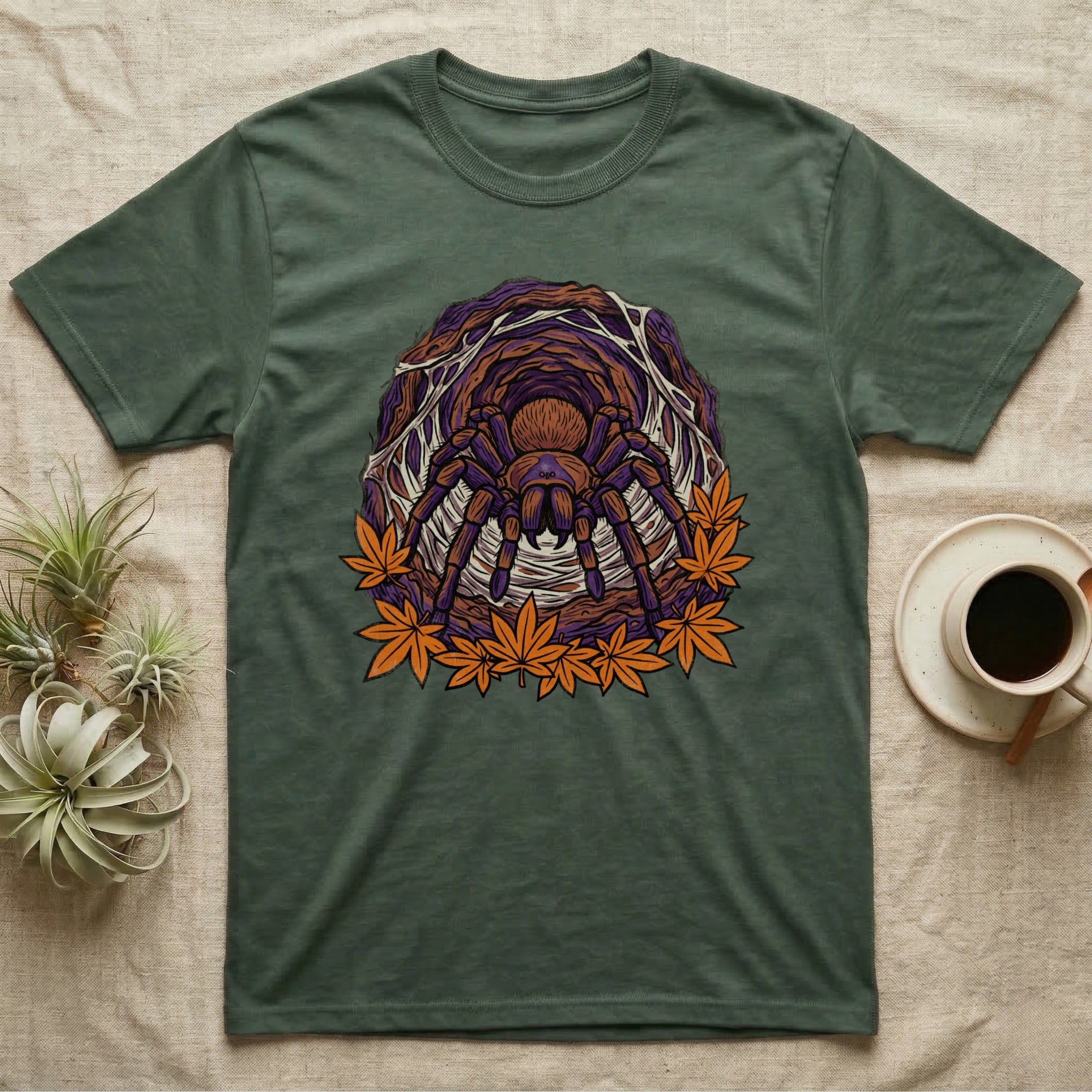 Green t-shirt with a tarantula and falling leaves graphic.