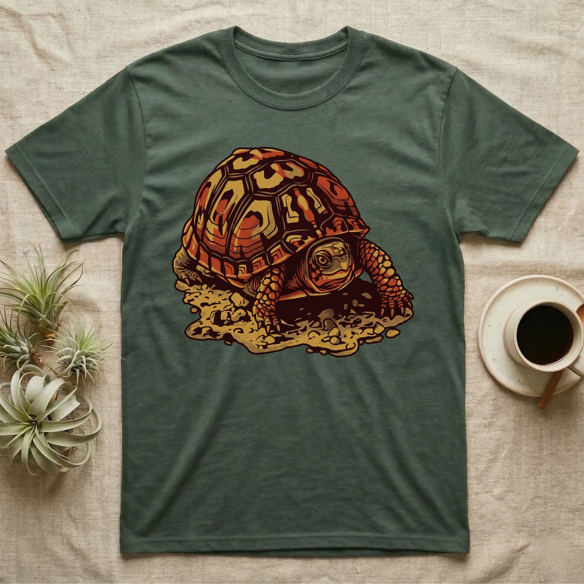 Vintage ink illustration of an Eastern box turtle crawling across sandy pebbles, high-domed shell shown in rust-red and amber, no on-shirt text. — shown on a Military Green tee.