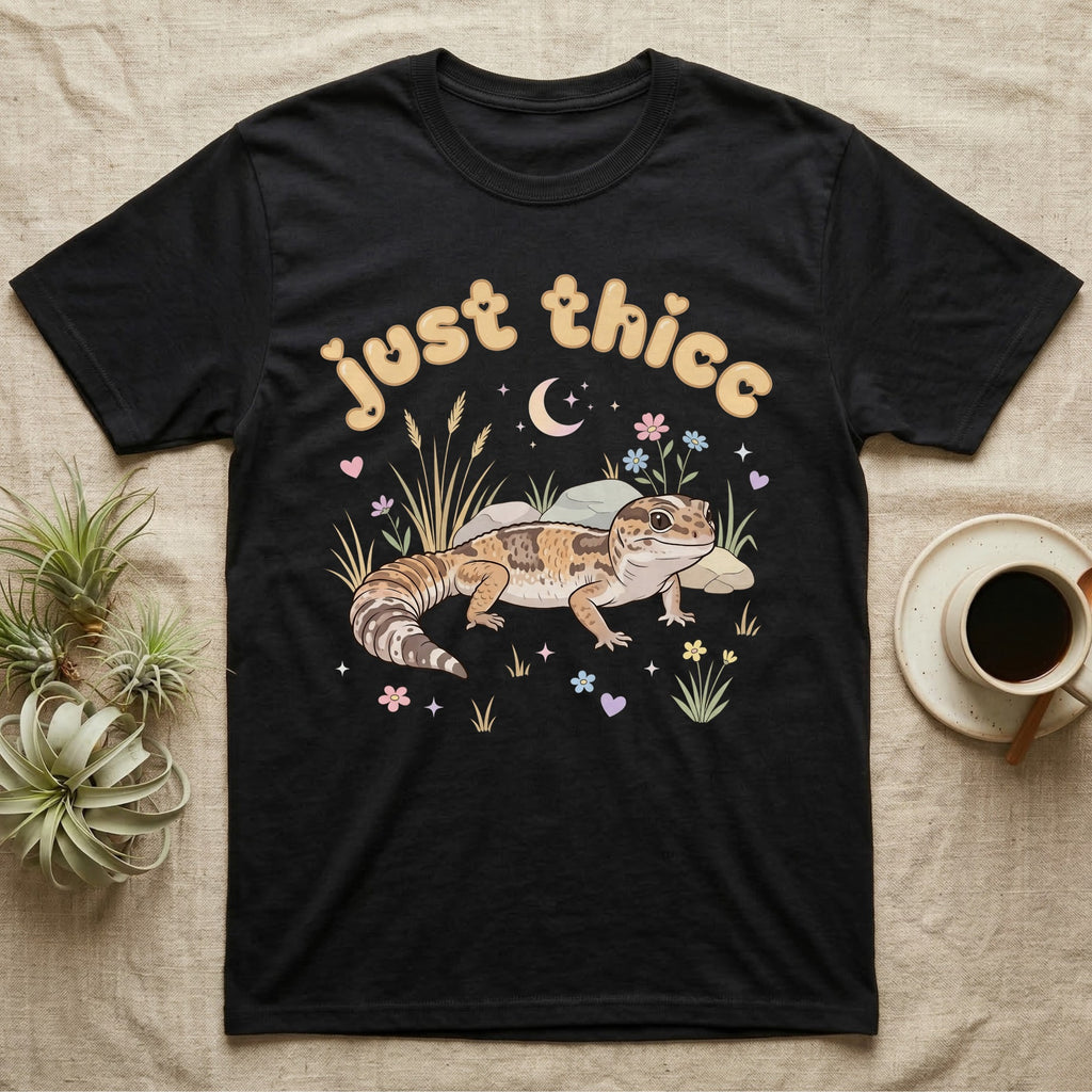 African Fat-Tailed Gecko Softie T-Shirt in Black — African fat-tailed gecko with a plump tail under a puffy pastel "just thicc" bubble wordmark with tiny hearts.