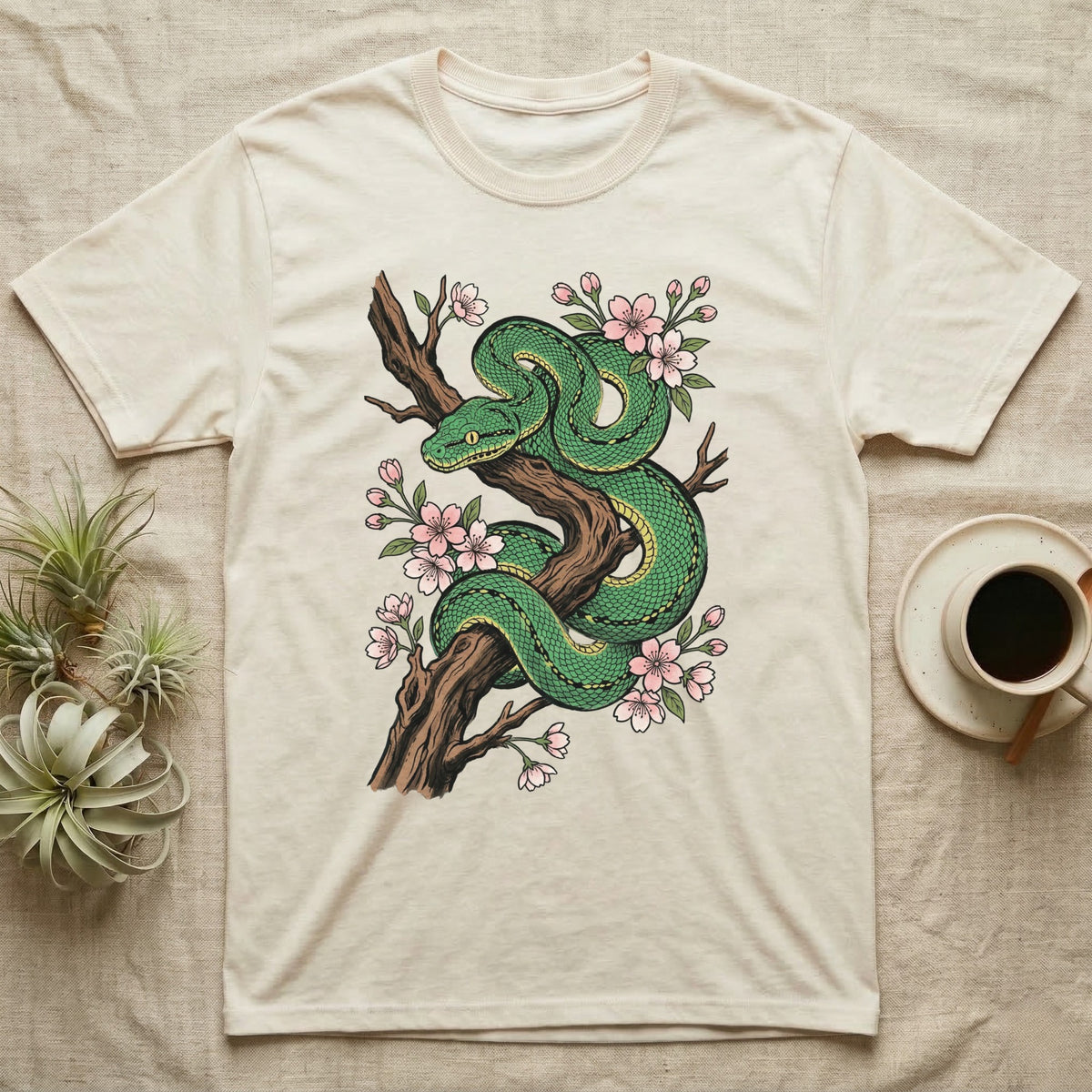 Green snake coiled on a branch with pink cherry blossoms.