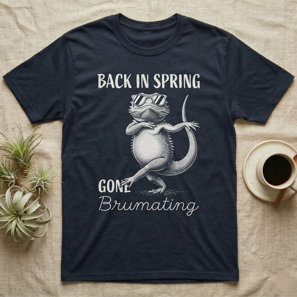 Bearded Dragon Brumating T-Shirt in Navy — Bearded dragon in striped sunglasses doing a dance step, retro text reads Back In Spring, Gone Brumating