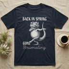 Bearded Dragon Brumating T-Shirt in Navy — Bearded dragon in striped sunglasses doing a dance step, retro text reads Back In Spring, Gone Brumating