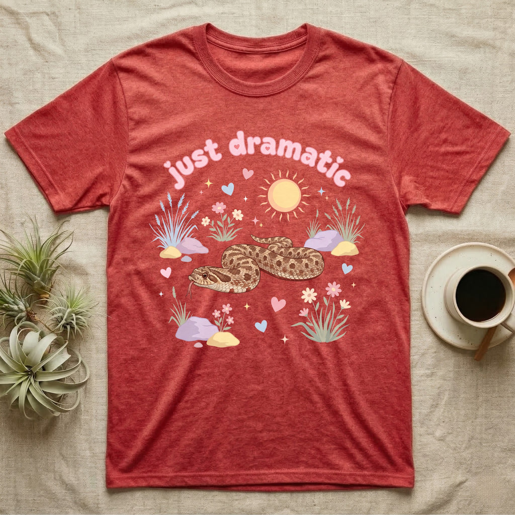 Western Hognose Snake Baby T-Shirt in Heather Red — Pastel western hognose snake in a low coil with tongue out among grasses, puffy pink bubble wordmark "just dramatic" above.