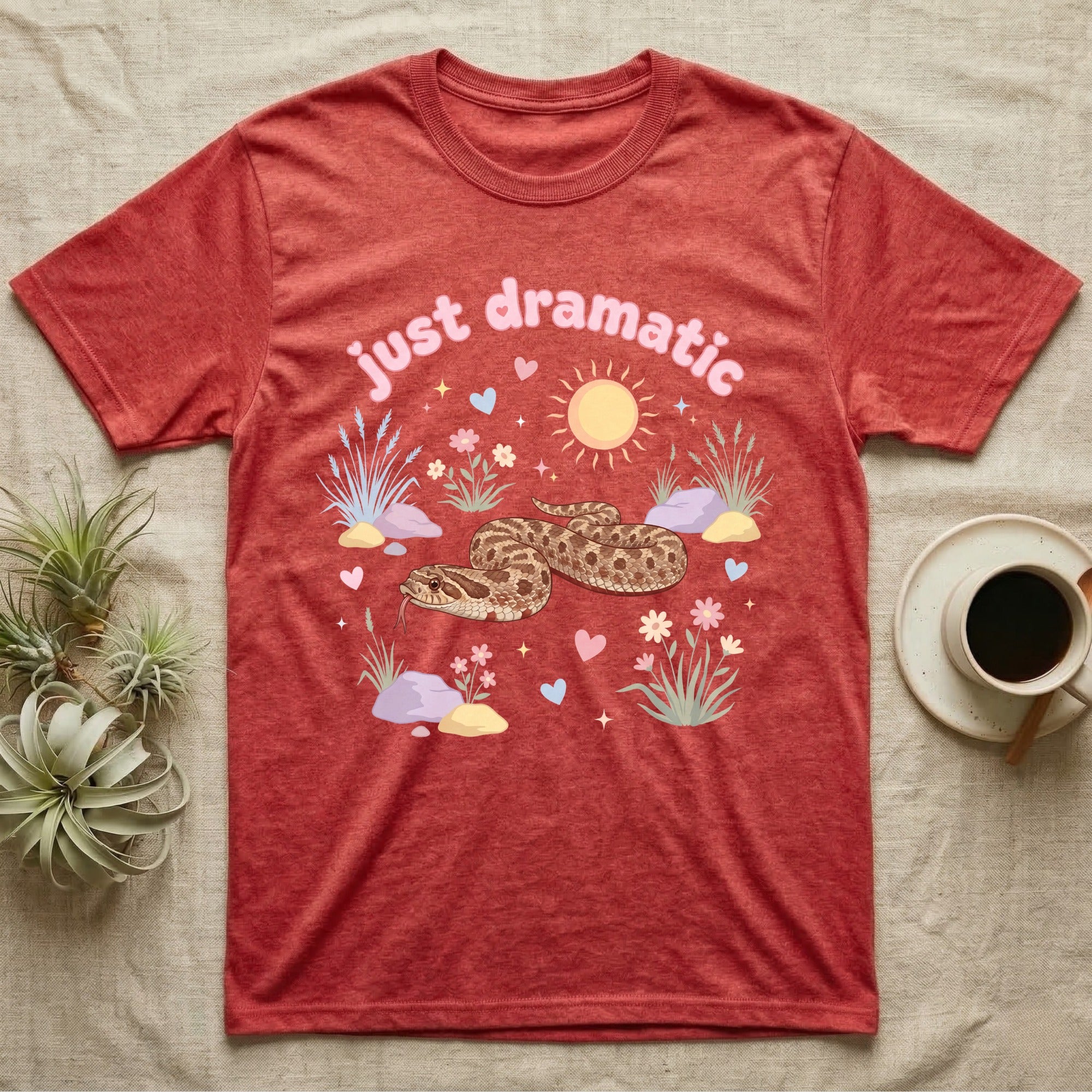 Western Hognose Snake Baby T-Shirt in Heather Red — Pastel western hognose snake in a low coil with tongue out among grasses, puffy pink bubble wordmark "just dramatic" above.