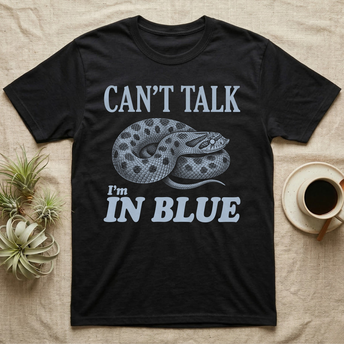 Hognose In Blue T-Shirt in Black — Milky blue engraved coiled western hognose with a cloudy pre-shed eye on black under the words CAN'T TALK, I'm IN BLUE