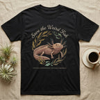 Axolotl Save Weird Fish T-Shirt in Black — Botanical axolotl with teal gill plumes inside a water-plant wreath; script type "Save the Weird Fish" arched above.