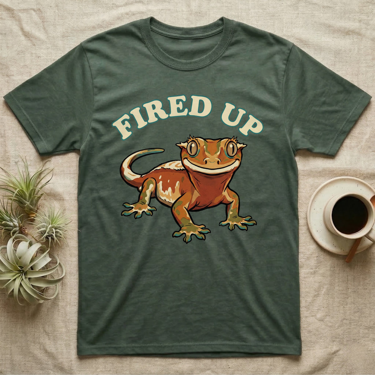 Fired Up Crested Gecko T-Shirt in Military Green — Retro 90s-style illustration of a fired-up crested gecko under a bold arc headline reading Fired Up.