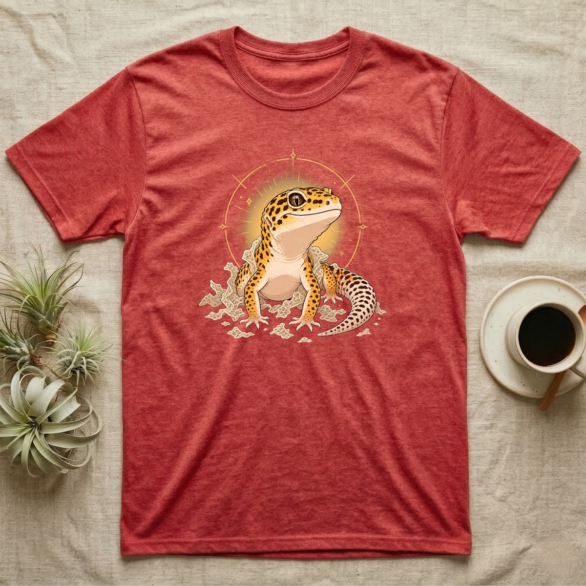 Leopard Gecko Shed T-Shirt in Heather Red — Bold vector illustration of a leopard gecko emerging fresh from a shed, lit by a soft warm halo glow.