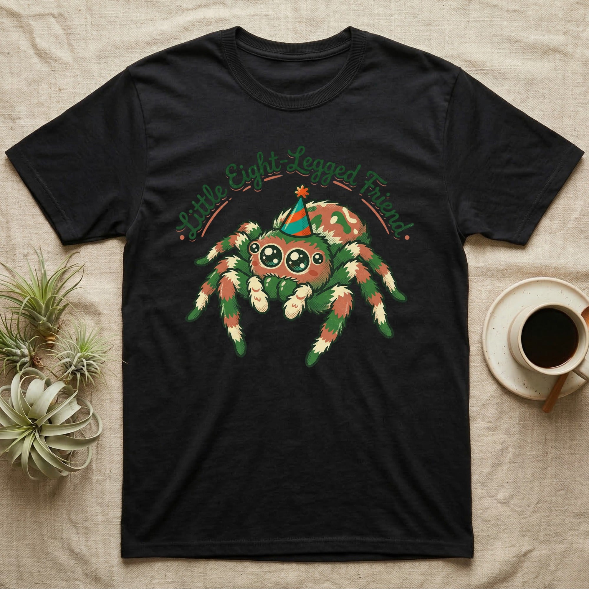 Black t-shirt with a festive cartoon spider wearing a party hat and the text "Little Eight Legged Friend".