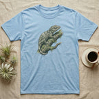 Light blue t-shirt with a detailed illustration of a gecko on a mossy branch.