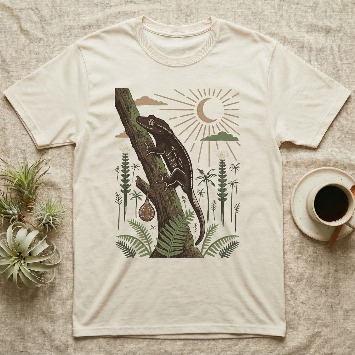 Crested Gecko Home Range T-Shirt in Natural — Woodcut-style illustration of a crested gecko clinging head-up to a mossy rainforest trunk among tree ferns, no on-shirt text.