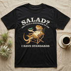 Bearded Dragon Standards T-Shirt in Black — Engraved bearded dragon in a camp chair holding greens topped with a hornworm under text Salad? Only With a Hornworm on Top