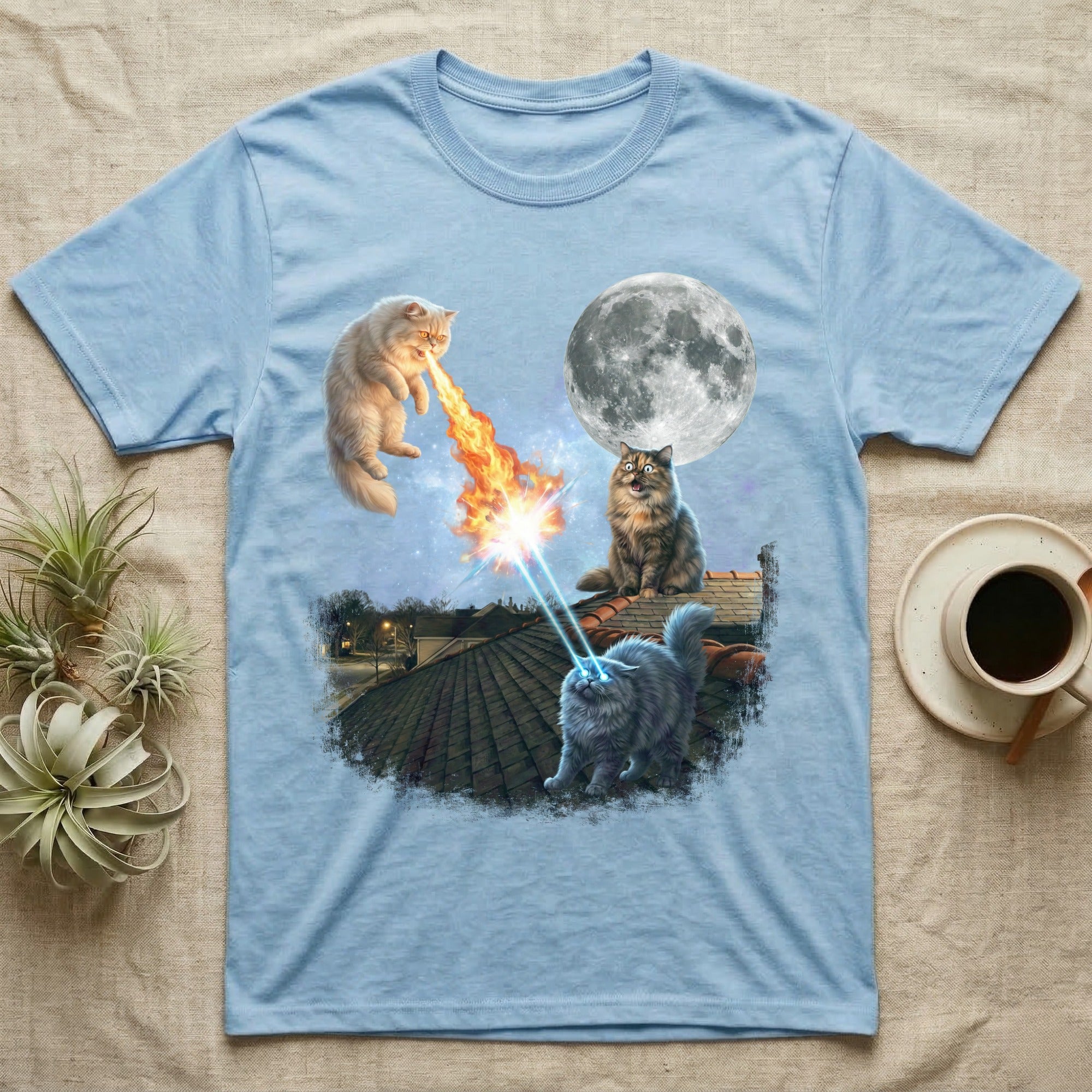 Light blue t-shirt with two cats on a rooftop, one breathing fire, the other with laser eyes, moon behind them.