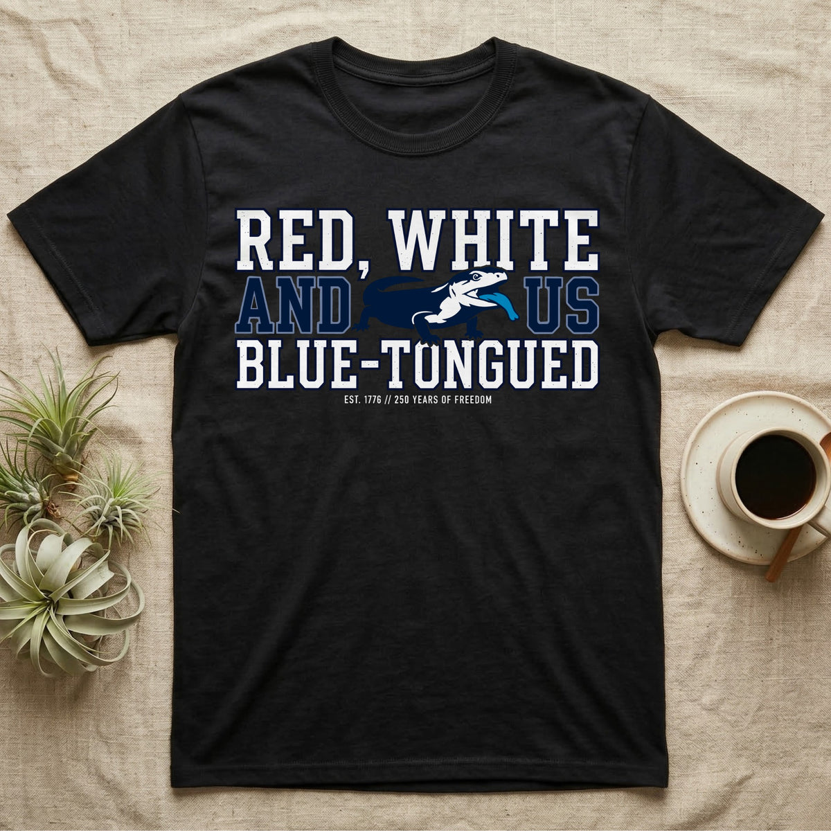 Blue-Tongued Skink 1776 T-Shirt in Black — Navy and white blue-tongued skink with tongue out between collegiate text reading Red, White and US Blue-Tongued.
