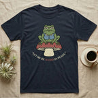 Navy t-shirt with frog sitting on a mushroom, text "Let me be weird in peace."